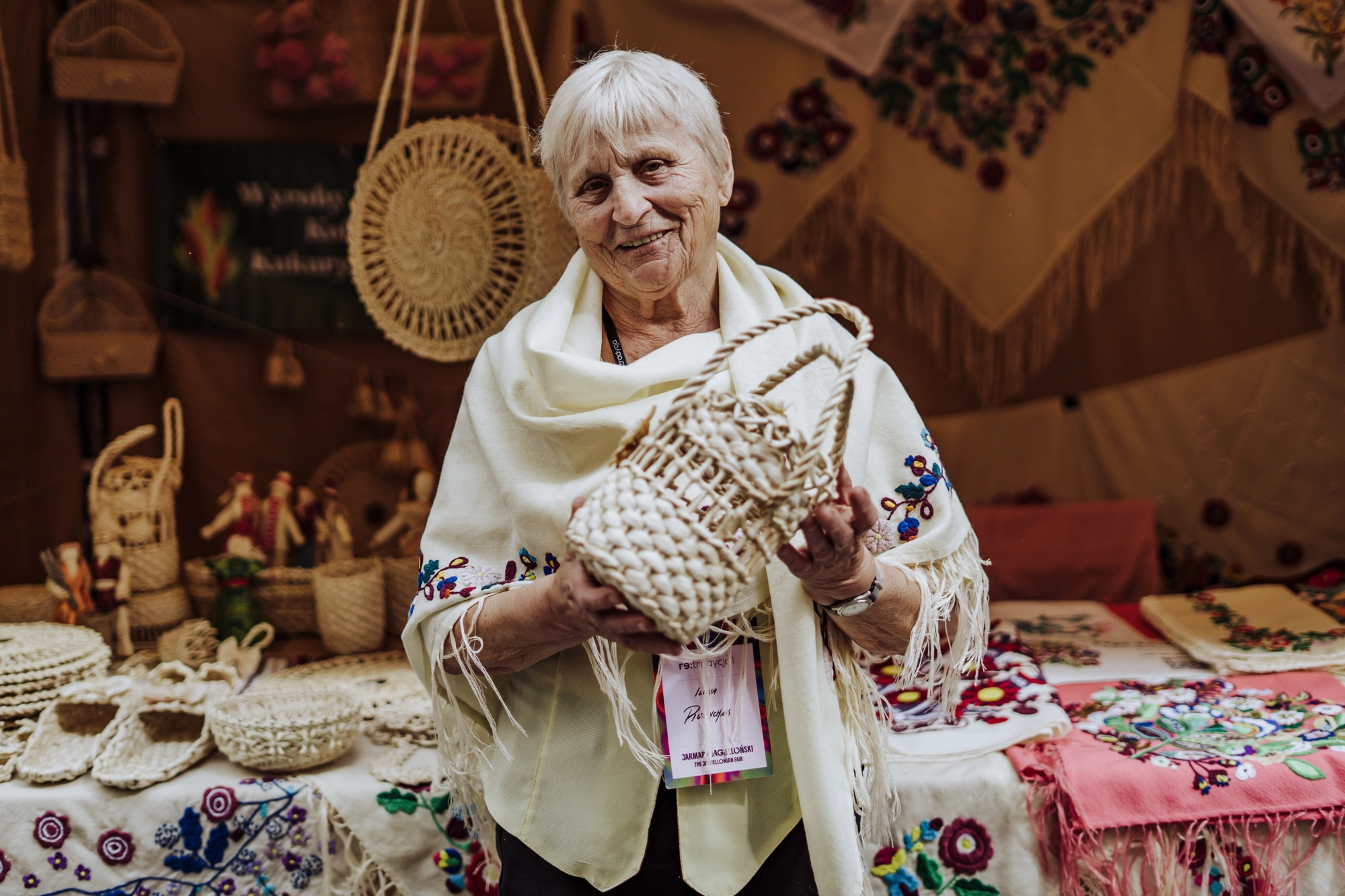 Portret twórczyni. Starsza kobieta trzyma w rękach