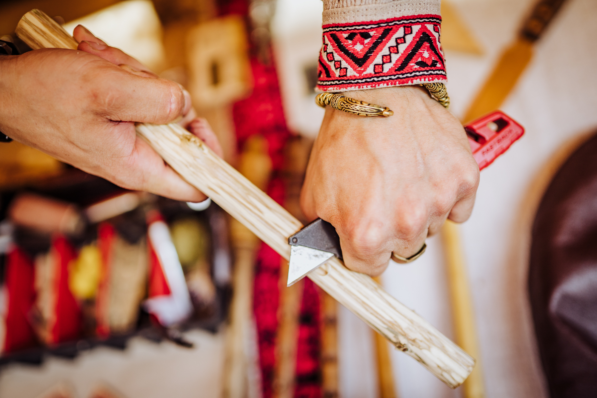 Mężczyzna na stoisku prezentuje, jak się robi flet.