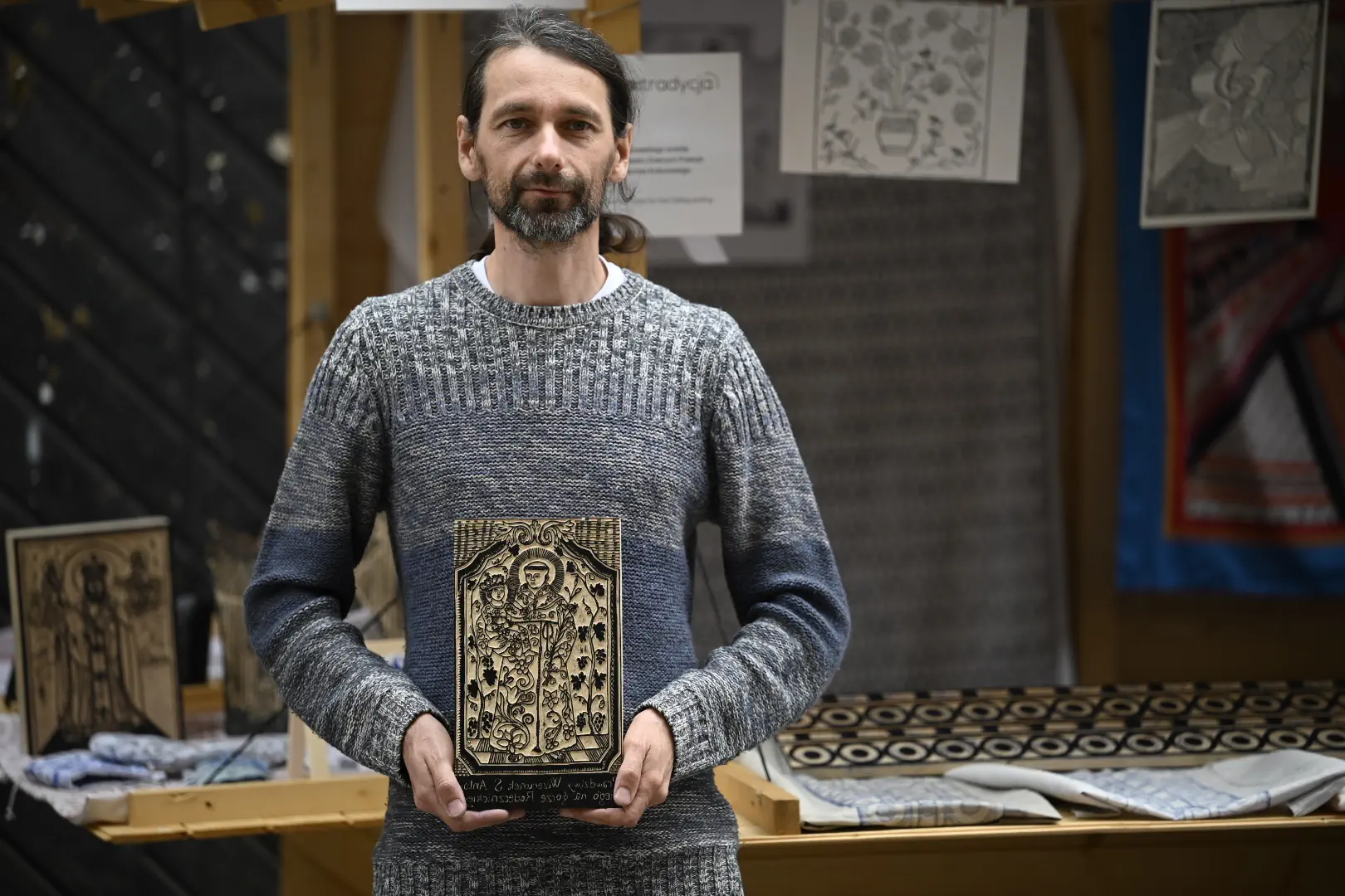 Mężczyzna trzyma w ręce drzeworyt.