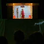 W sali jest ciemno. Jasne jest tylko wnętrze szopki, w której poruszają się lalki.