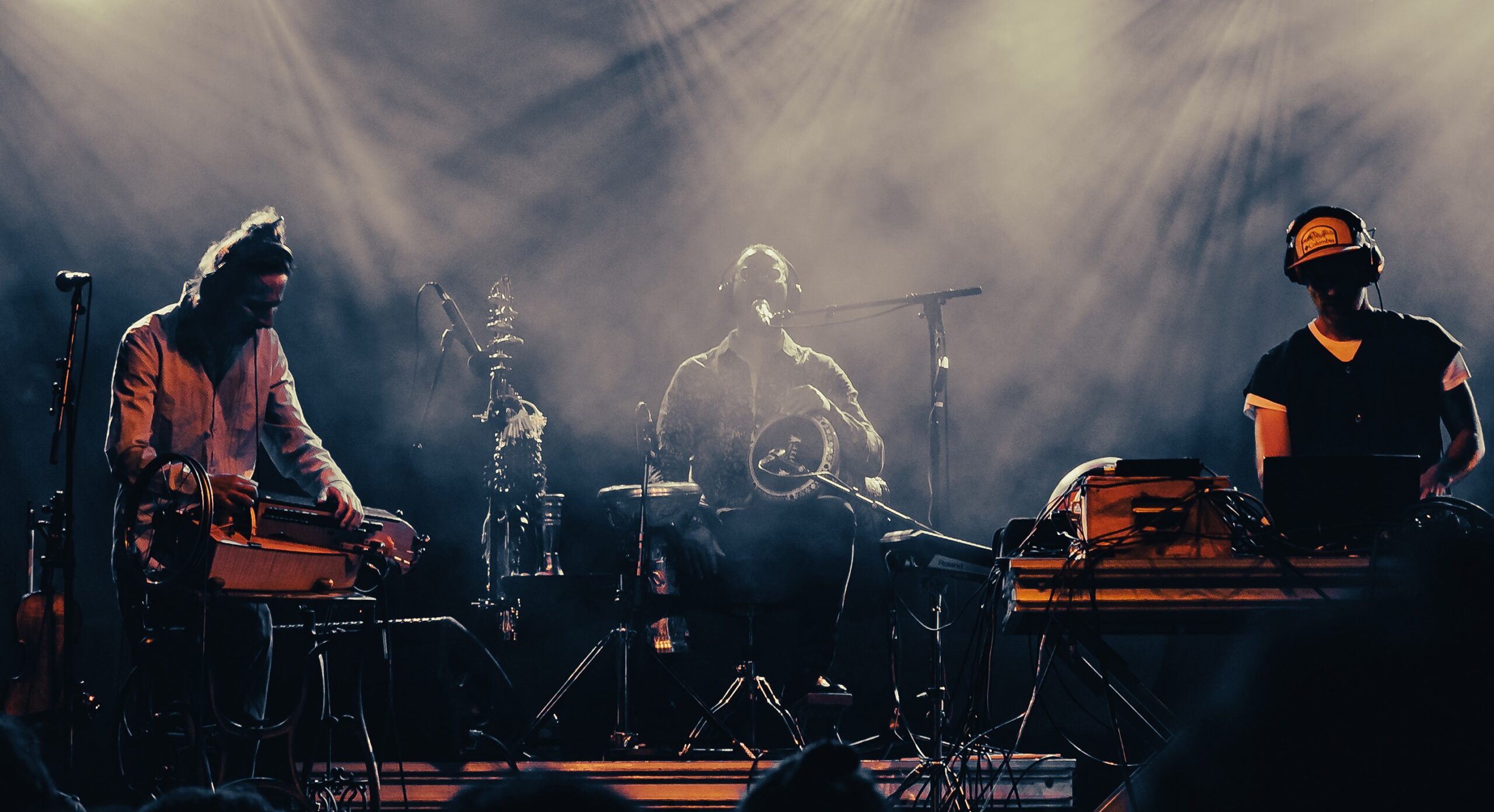 Trzy osoby dają koncert na scenie.